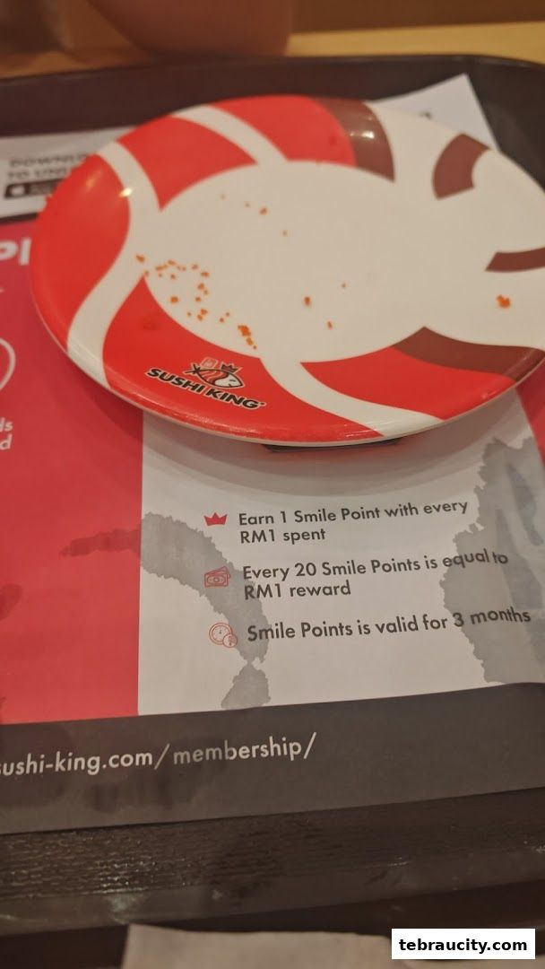 A Sushi King plate with a membership promotion on a table.