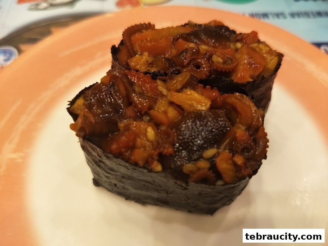Close-up of two pieces of sushi with octopus and other ingredients wrapped in seaweed.