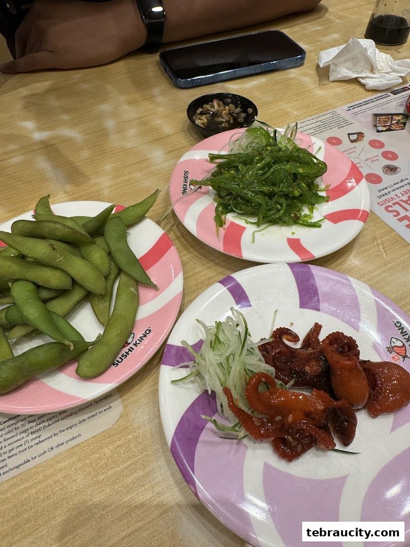 Plates of edamame, seaweed salad, and baby octopus served at Sushi King.