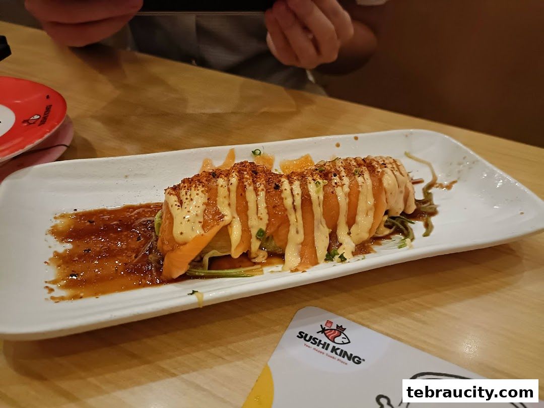 A plate of sushi with salmon and sauce, with a Sushi King card in the foreground.