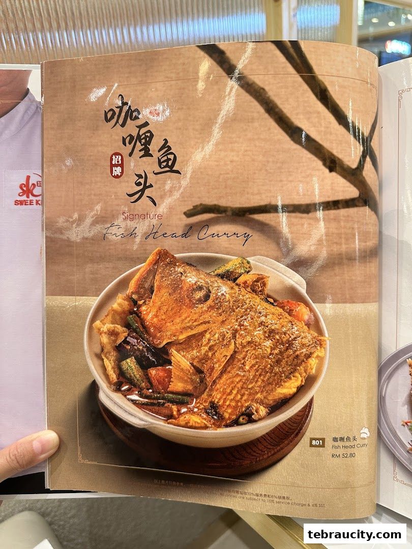 A menu page featuring a signature fish head curry dish with ingredients.