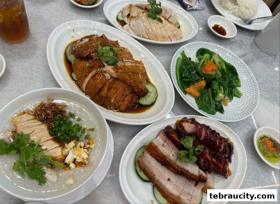 A table laden with various delicious chicken rice dishes and side dishes.