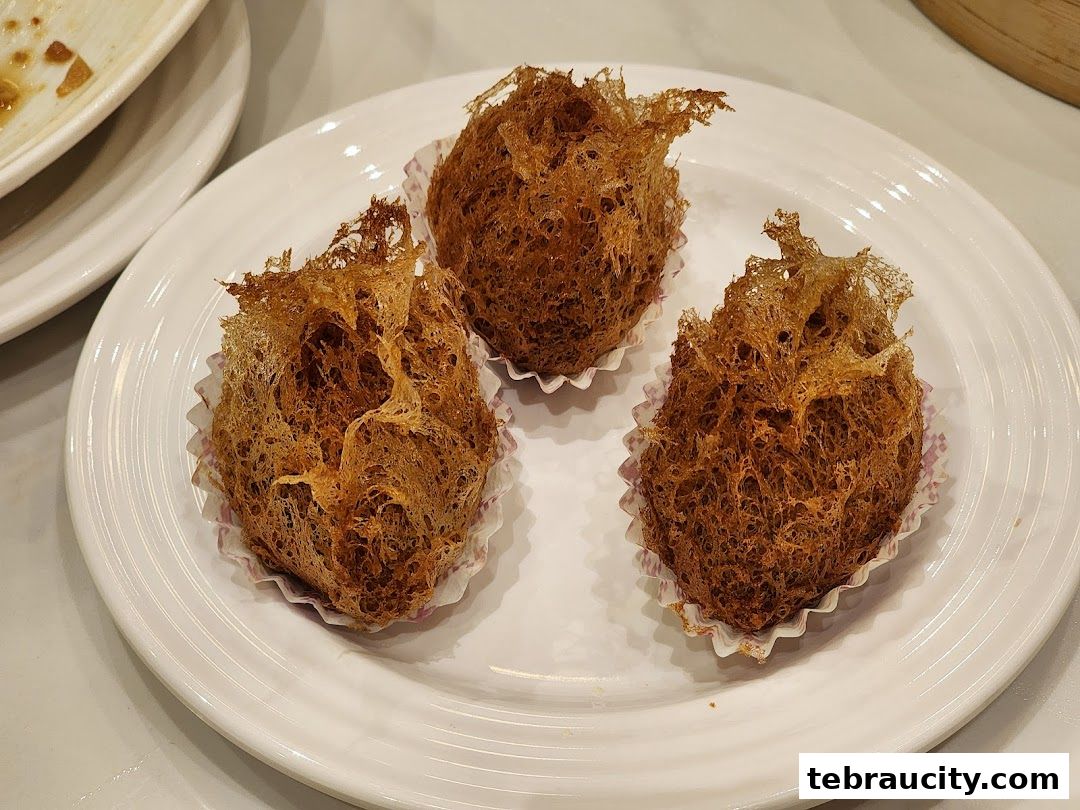 Three crispy fried taro balls served on a white plate.