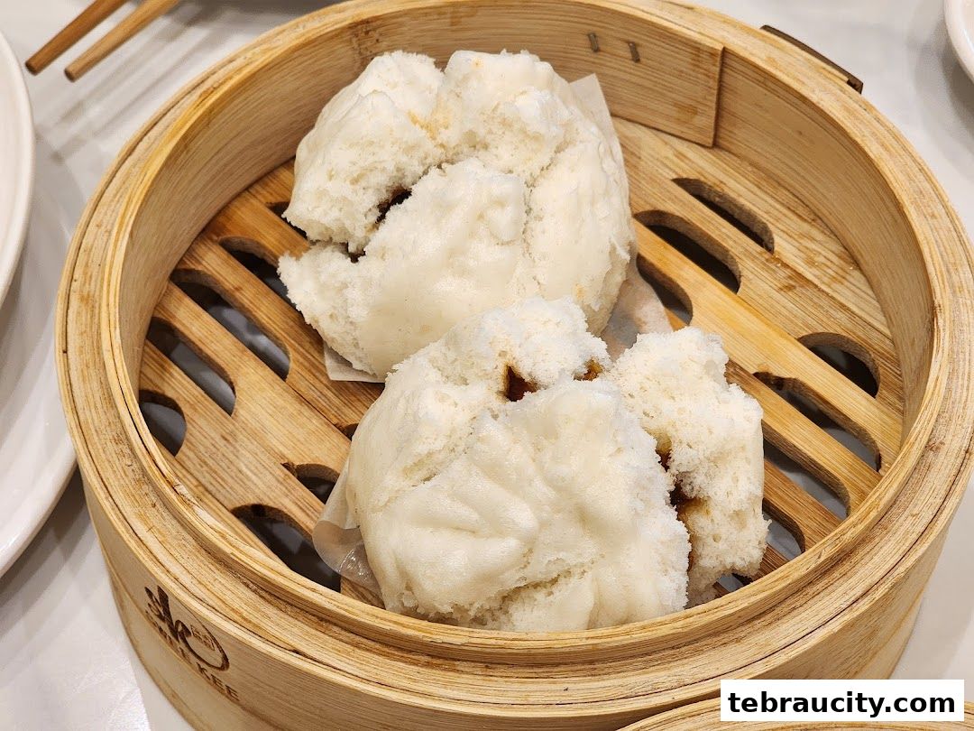 Steamed buns served in a bamboo steamer basket, a popular dim sum dish.