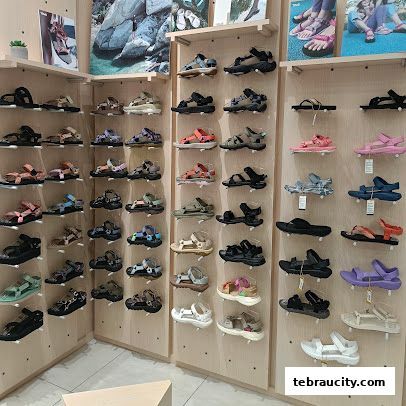 A wide selection of Teva sandals displayed on shelves in a retail store.