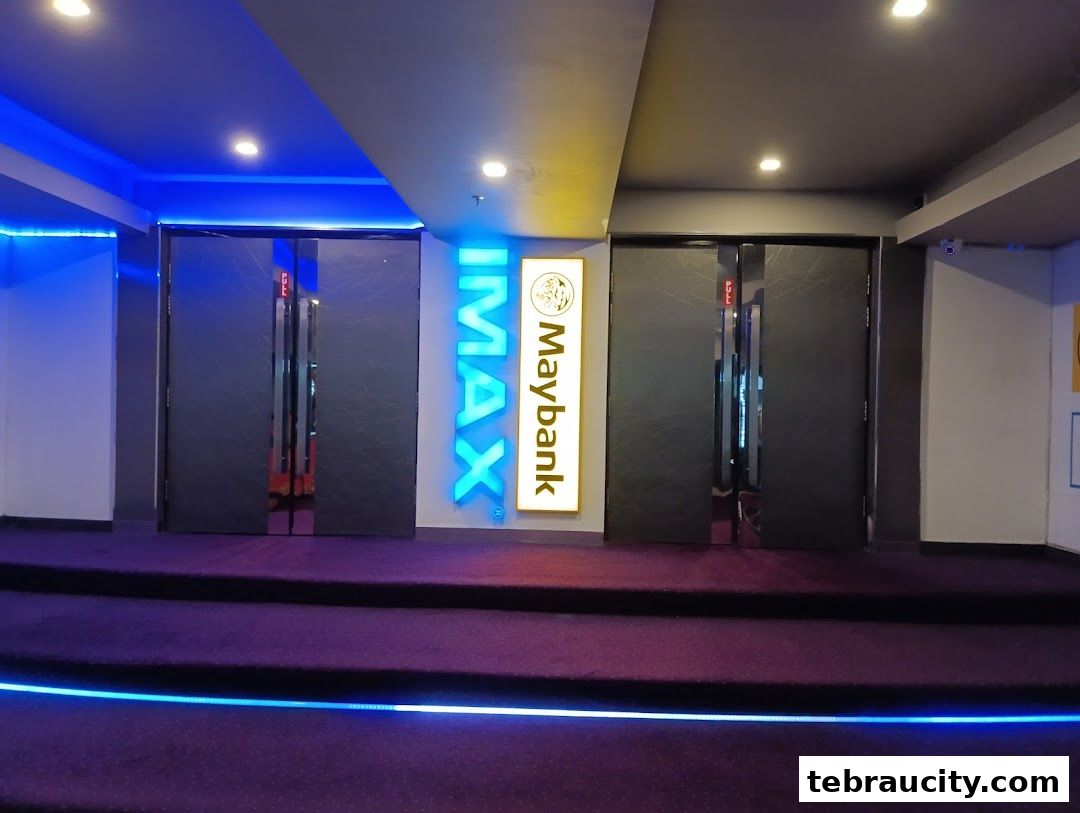 The entrance to an IMAX cinema with illuminated signage and plush carpeting.