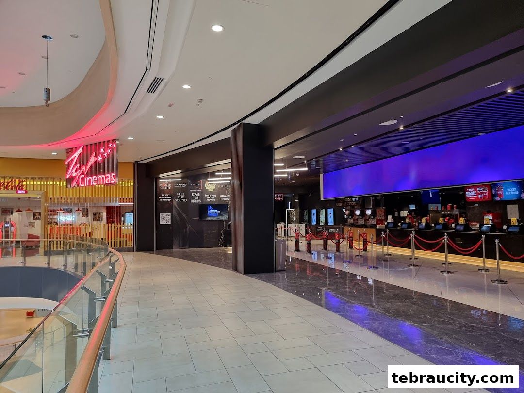 Interior view of a modern cinema lobby with ticket counters and seating areas.