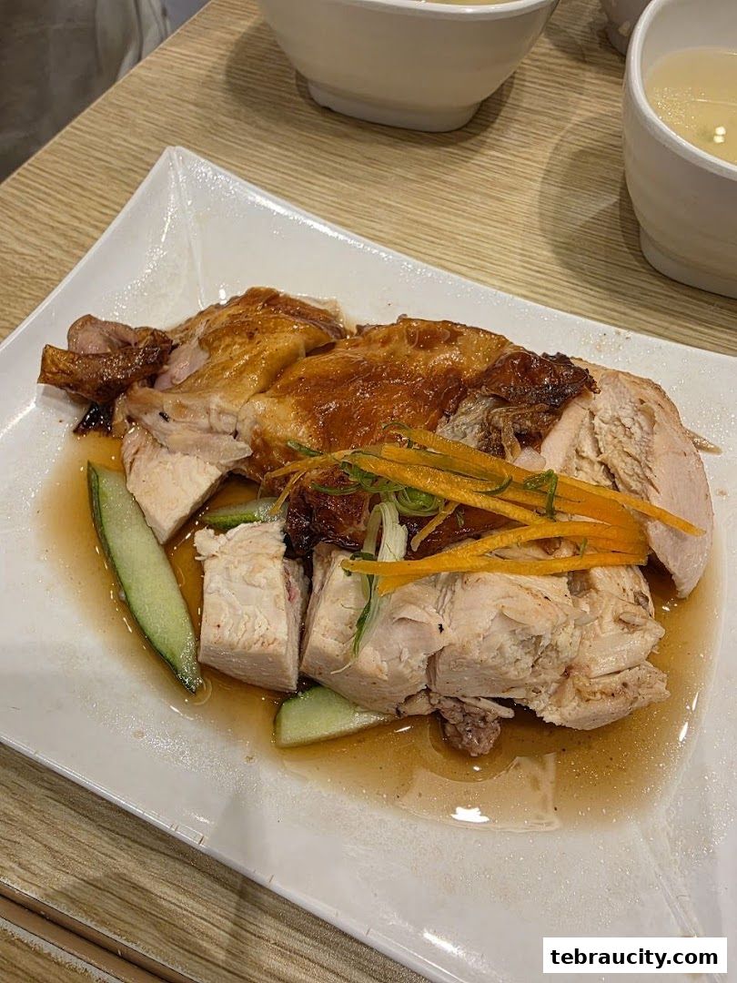 A plate of delicious roasted chicken with cucumber and carrots, served with soup.