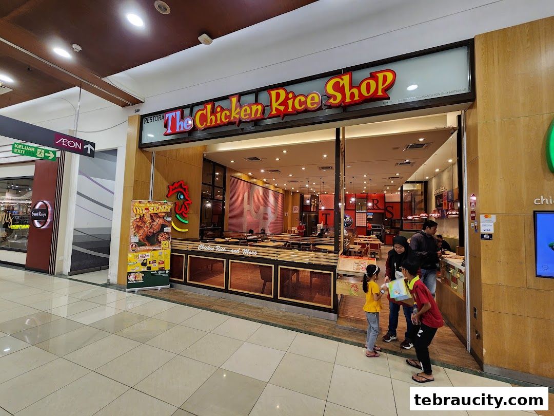 The Chicken Rice Shop storefront with customers entering and a promotional banner outside.