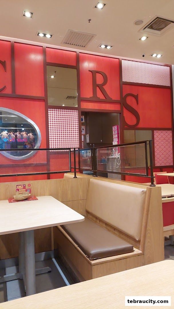 Interior view of The Chicken Rice Shop with seating and decorative wall.