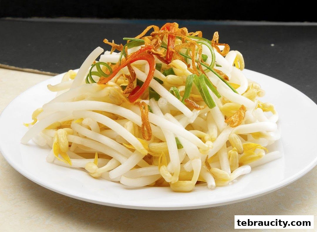 A plate of fresh bean sprouts with chili and fried shallots, garnished with spring onions.