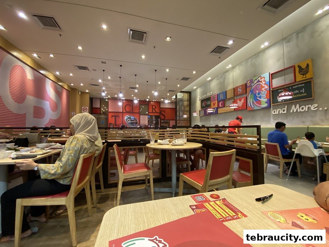 Interior view of The Chicken Rice Shop with diners and colorful wall art.