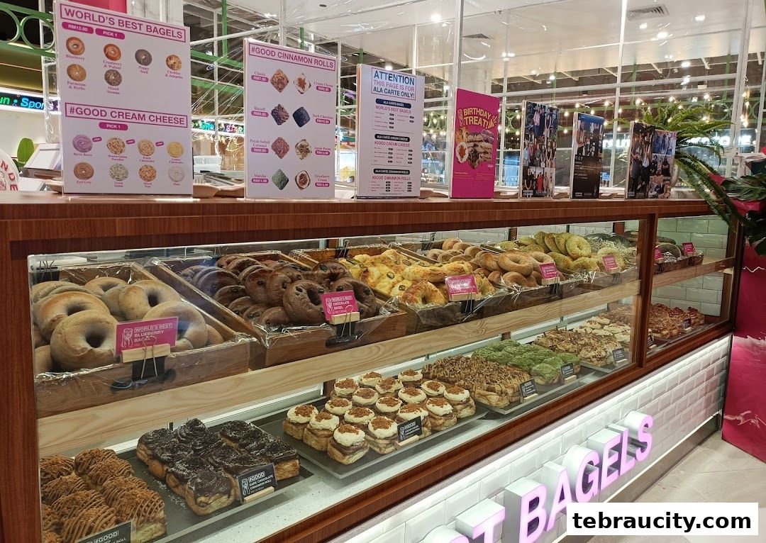 A display case filled with various bagels, cinnamon rolls, and other baked goods at The Founders Bakery.