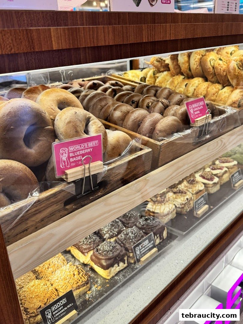 A display case filled with various freshly baked bagels and cinnamon rolls at The Founders Bakery.
