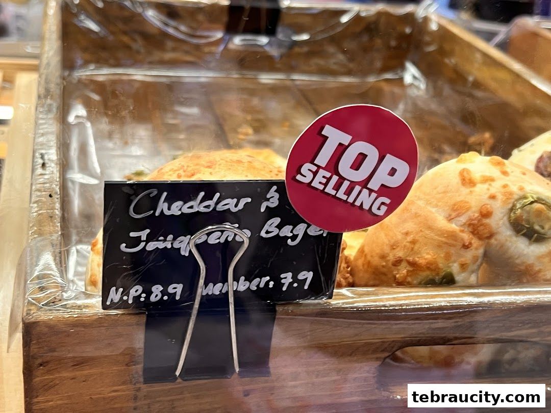 A close-up of a 'Cheddar & Jalapeno Bagel' with a 'Top Selling' sticker.