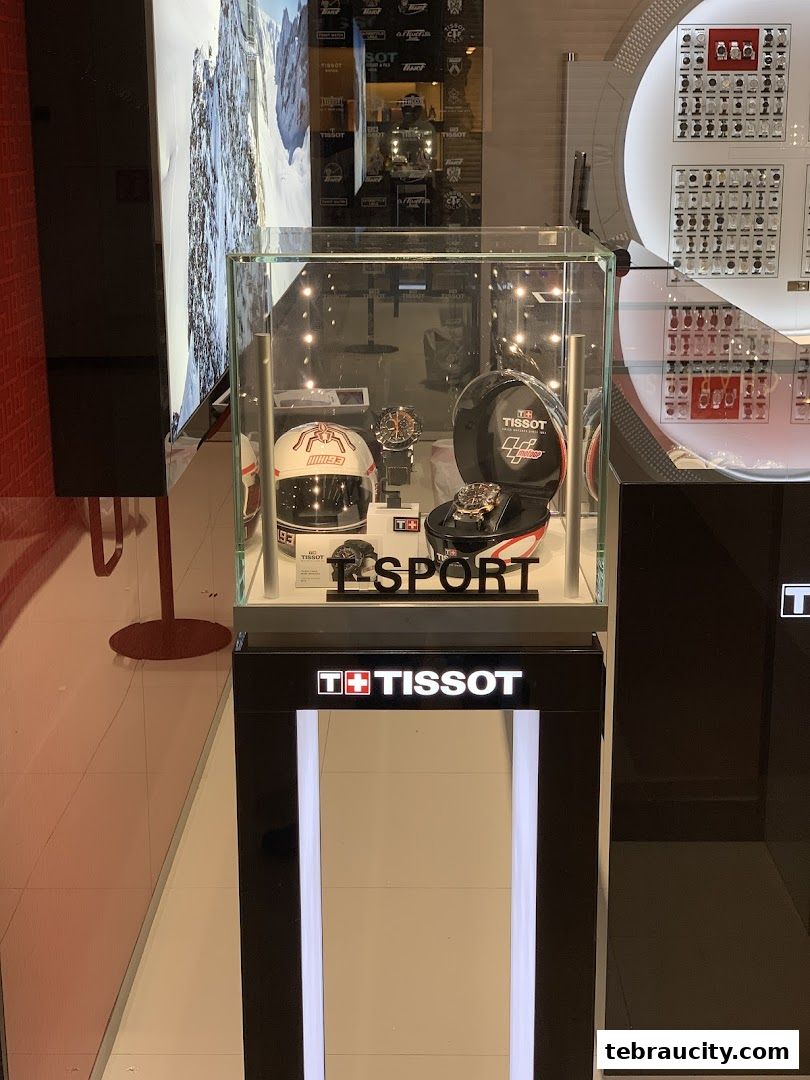 A Tissot display case featuring watches and a racing helmet.