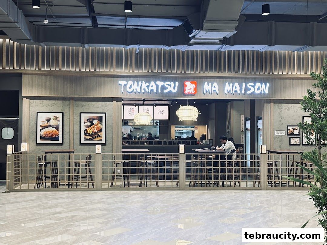 The exterior of Tonkatsu by Ma Maison restaurant with its prominent signage and inviting seating area.