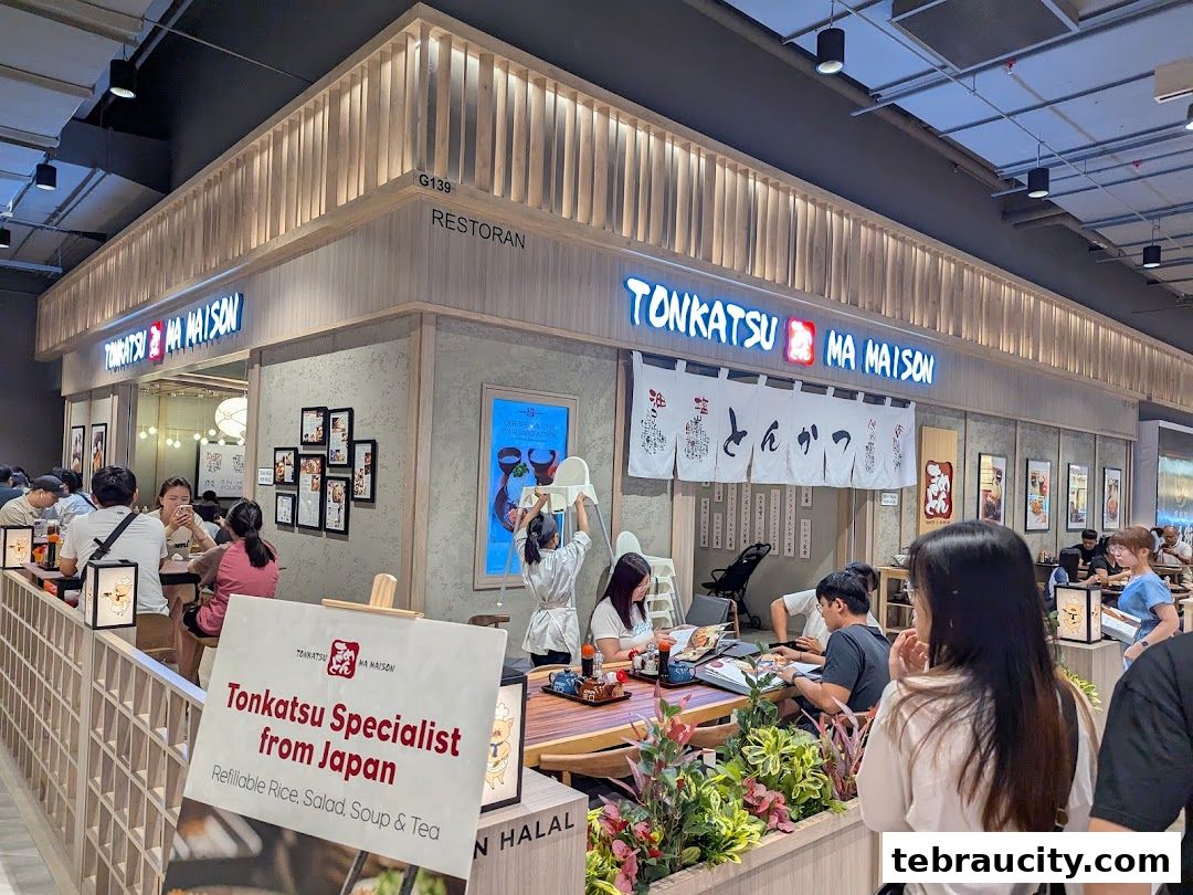 The exterior of Tonkatsu by Ma Maison restaurant with customers dining inside.