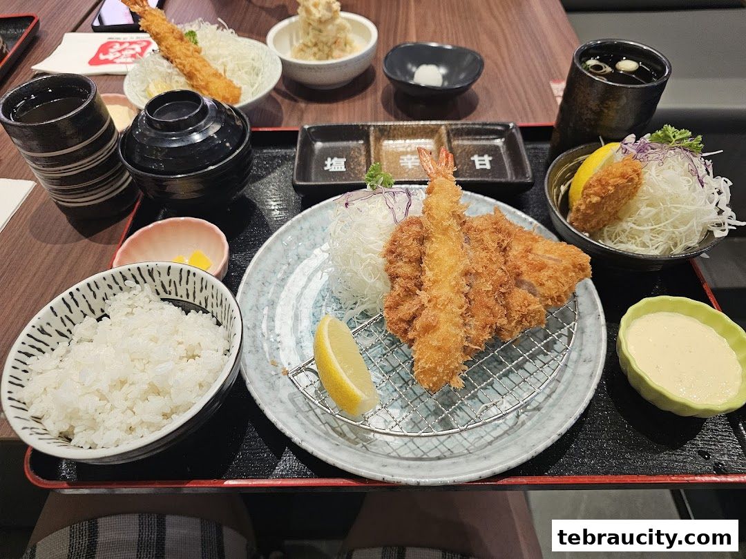 A delicious spread of Japanese fried dishes, including tonkatsu and tempura, served with rice and dipping sauce.