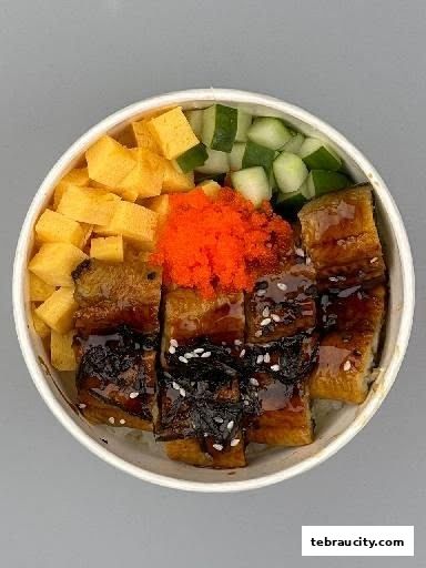 A bowl of Unagi Don with grilled eel, tamagoyaki, cucumber, and tobiko.