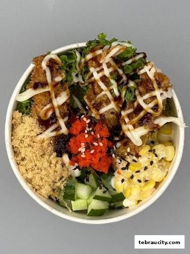 A delicious bowl of sushi with various toppings, including fried chicken, corn, and roe.