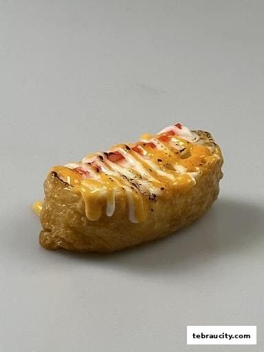 A close-up shot of a delicious sushi inari pocket topped with creamy sauces and spices.