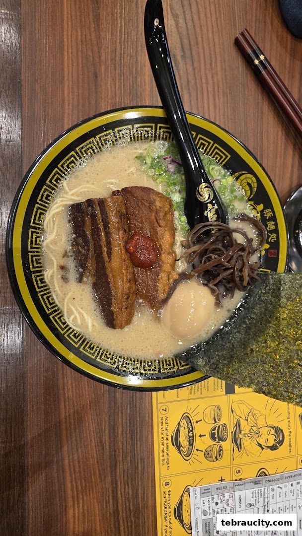 A delicious bowl of ramen with thick pork belly, egg, and seaweed.
