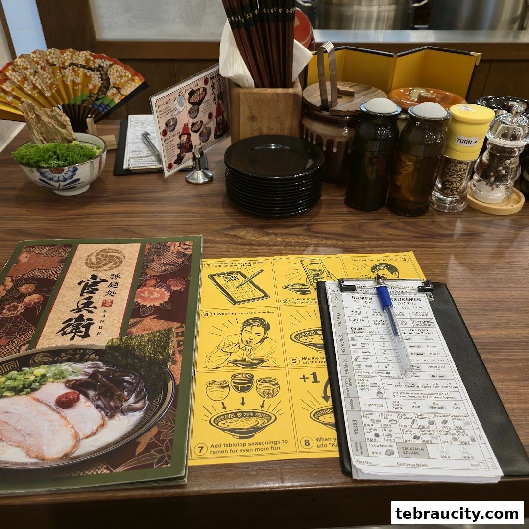 A table setting at a ramen restaurant with menus, chopsticks, and condiments.