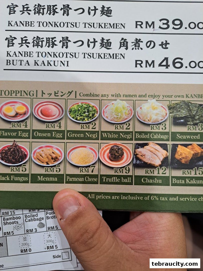 A menu for Kanbe Tonkotsu Tsukemen ramen with various toppings and prices.