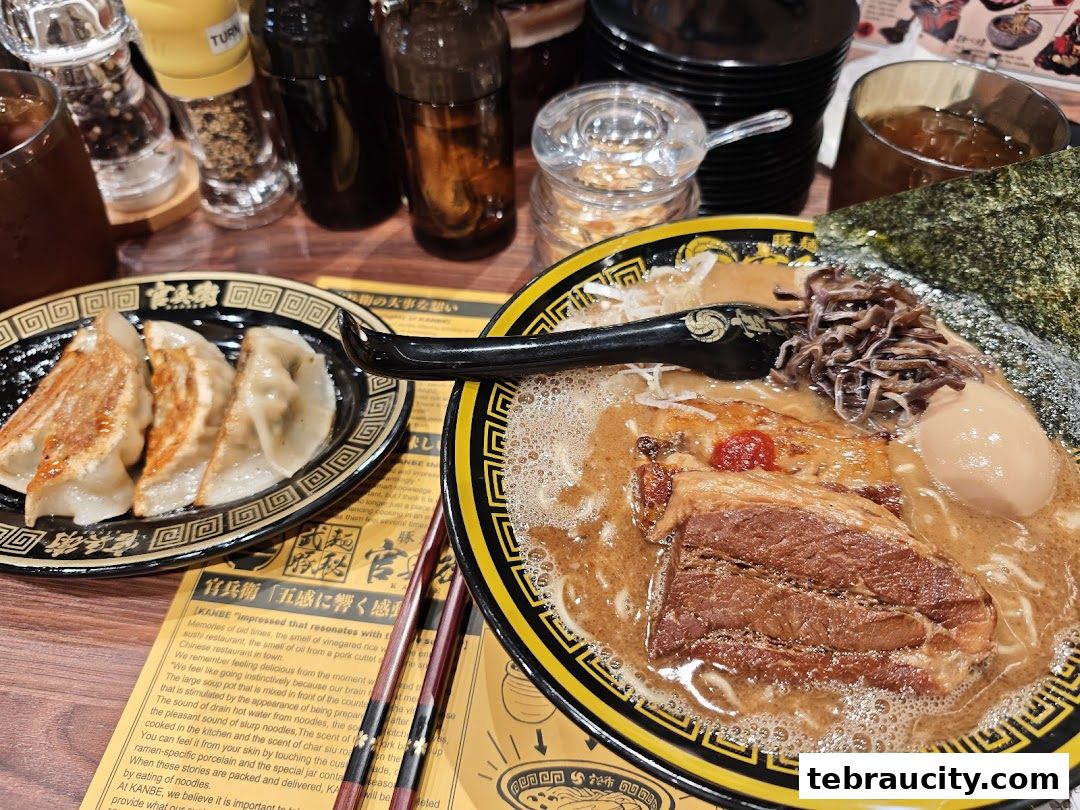 A close-up of a delicious ramen bowl with chashu pork and a side of gyoza.