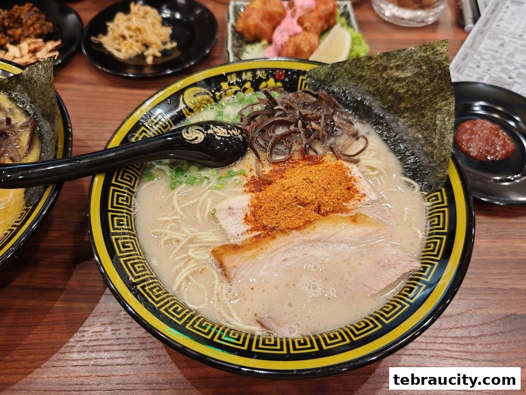 A close-up of a steaming bowl of ramen with pork, seaweed, and spices.