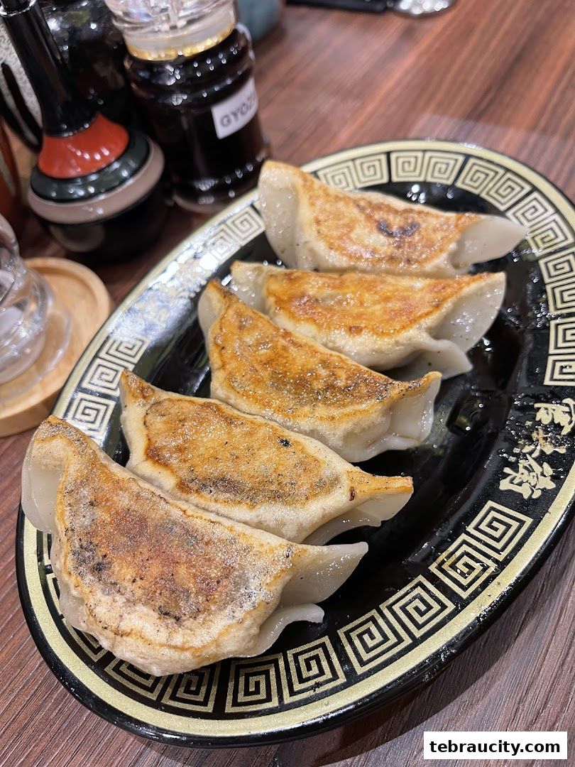 A plate of pan-fried gyoza dumplings served at a ramen restaurant.