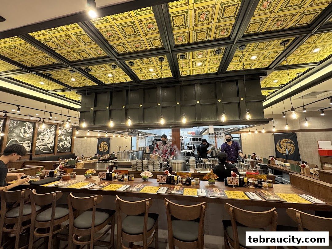 Interior of a ramen shop with a counter seating area and an open kitchen.