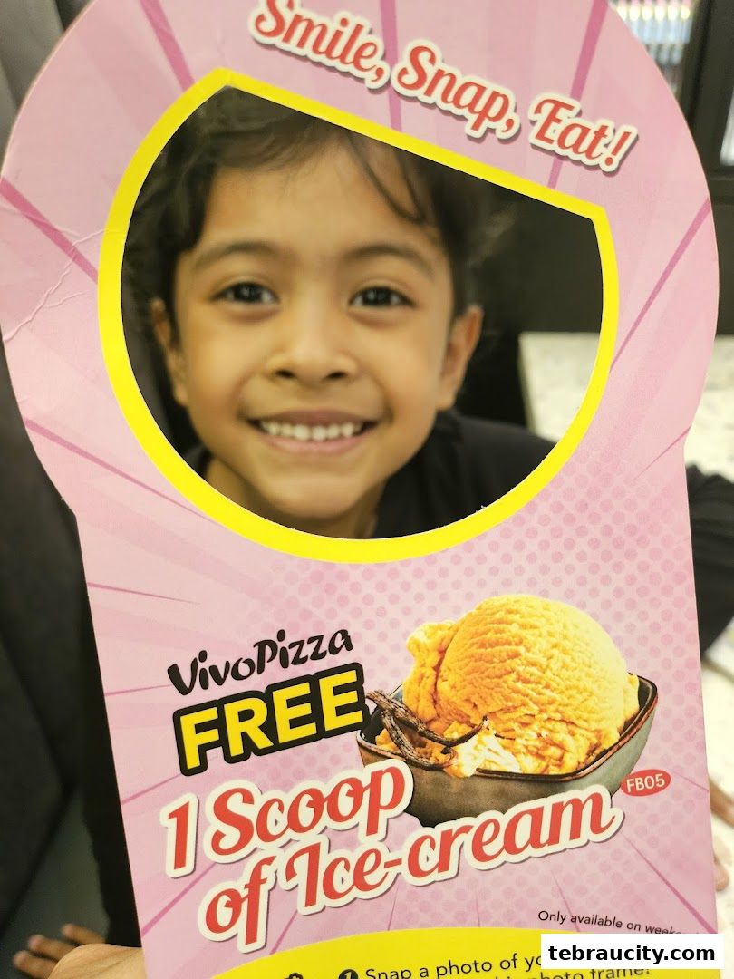 A child smiles through a cutout on a promotional flyer offering free ice cream.