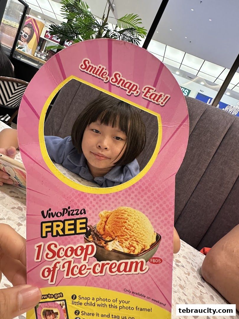 A child smiles through a cutout on a promotional flyer for Vivo Pizza offering free ice cream.