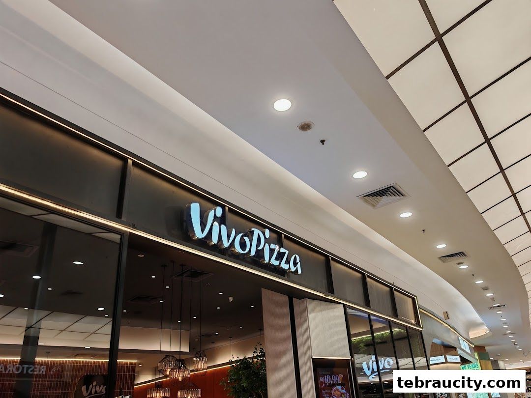 The illuminated Vivo Pizza sign is displayed prominently above the shop entrance.