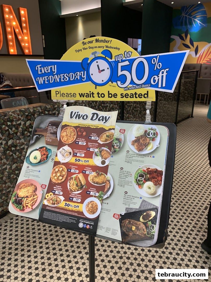 A menu board displays Vivo Pizza's Wednesday deals with various food items and discounts.