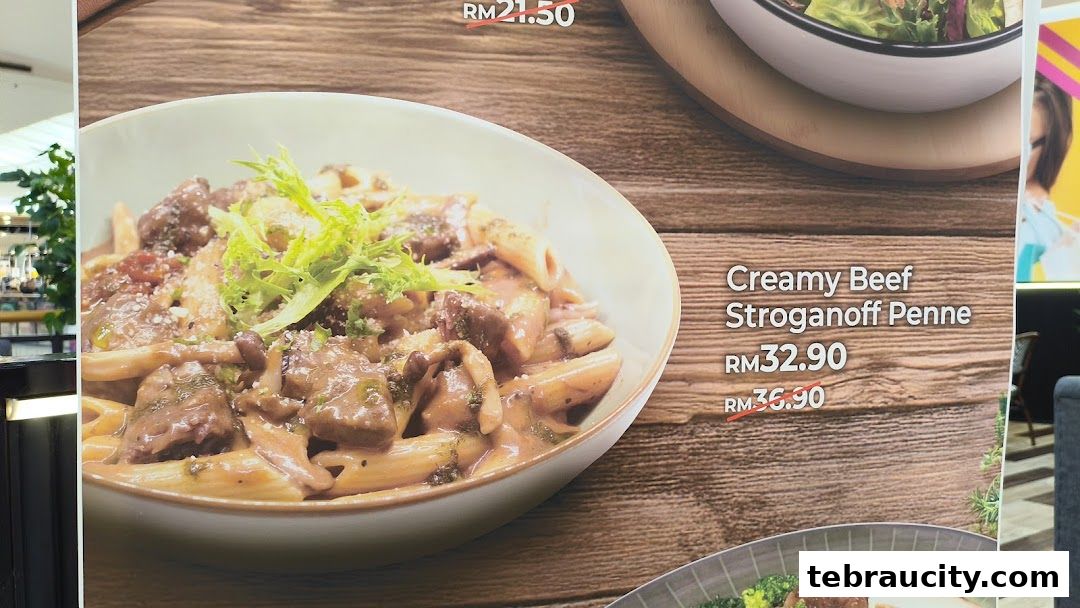 A close-up of a creamy beef stroganoff penne dish with prices displayed.