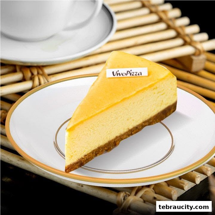 A slice of cheesecake with a Vivo Pizza flag on a plate, next to a cup and saucer.