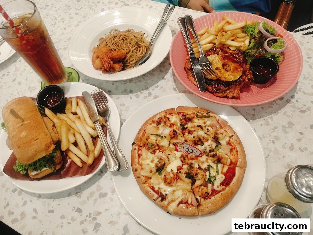 A table laden with various dishes including pizza, pasta, a sandwich, and a chicken steak with fries.