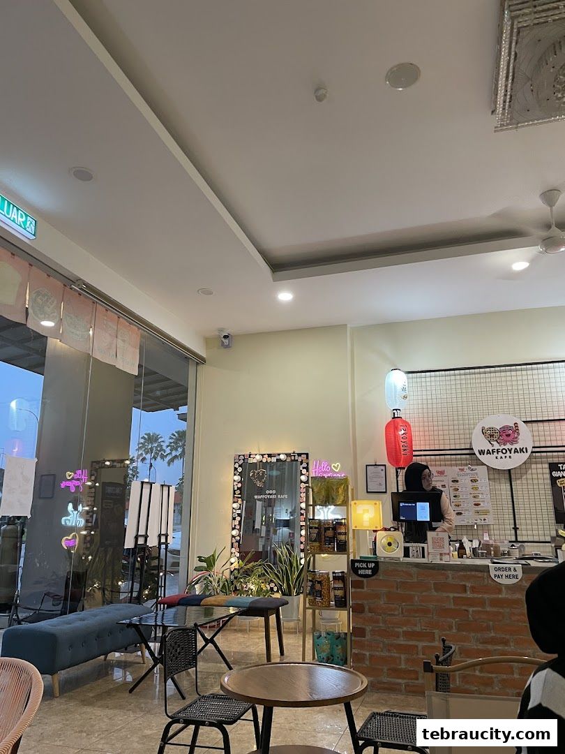 Interior of Waffoyaki Kafe with seating, counter, and staff serving customers.