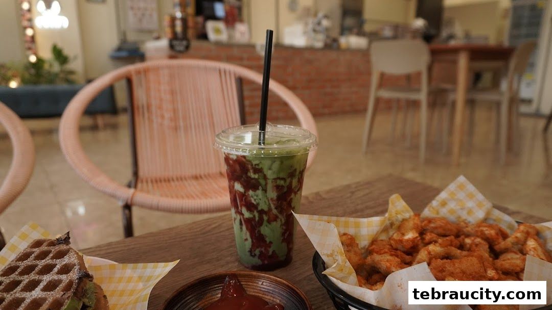 A table at Waffoyaki Kafe with a waffle, a green drink, and fried chicken.