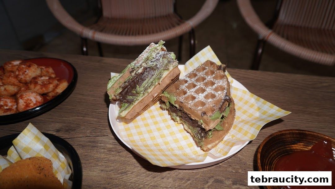 A close-up of two delicious-looking waffles filled with chocolate and green cream, dusted with powdered sugar.