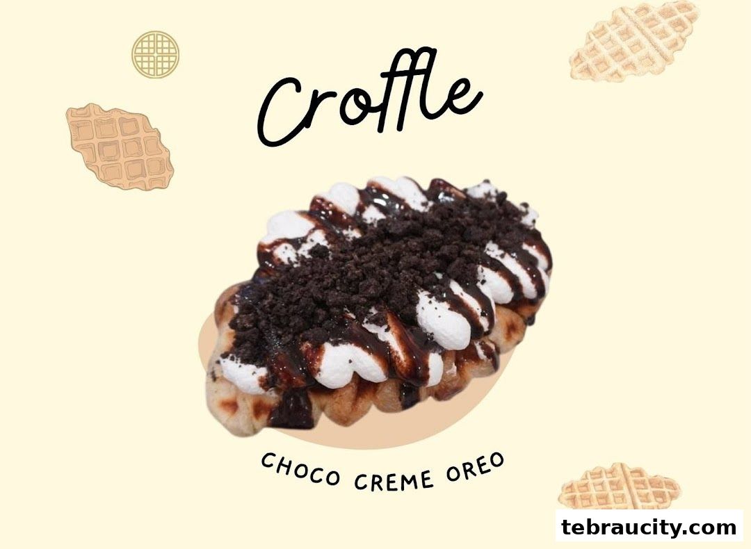 A delicious-looking croffle topped with cream, chocolate sauce, and cookie crumbs.