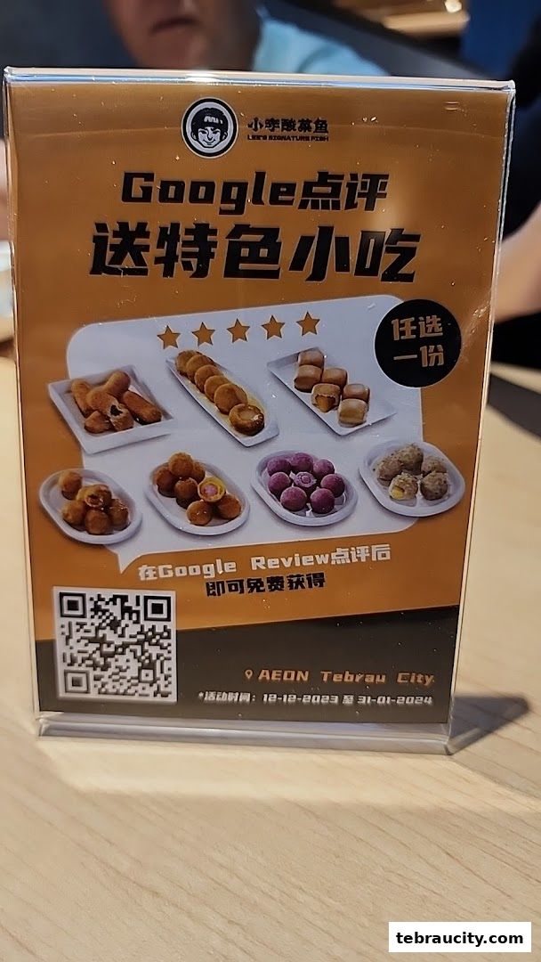 A promotional sign for Lees Signature Fish offering a free snack with a Google review.