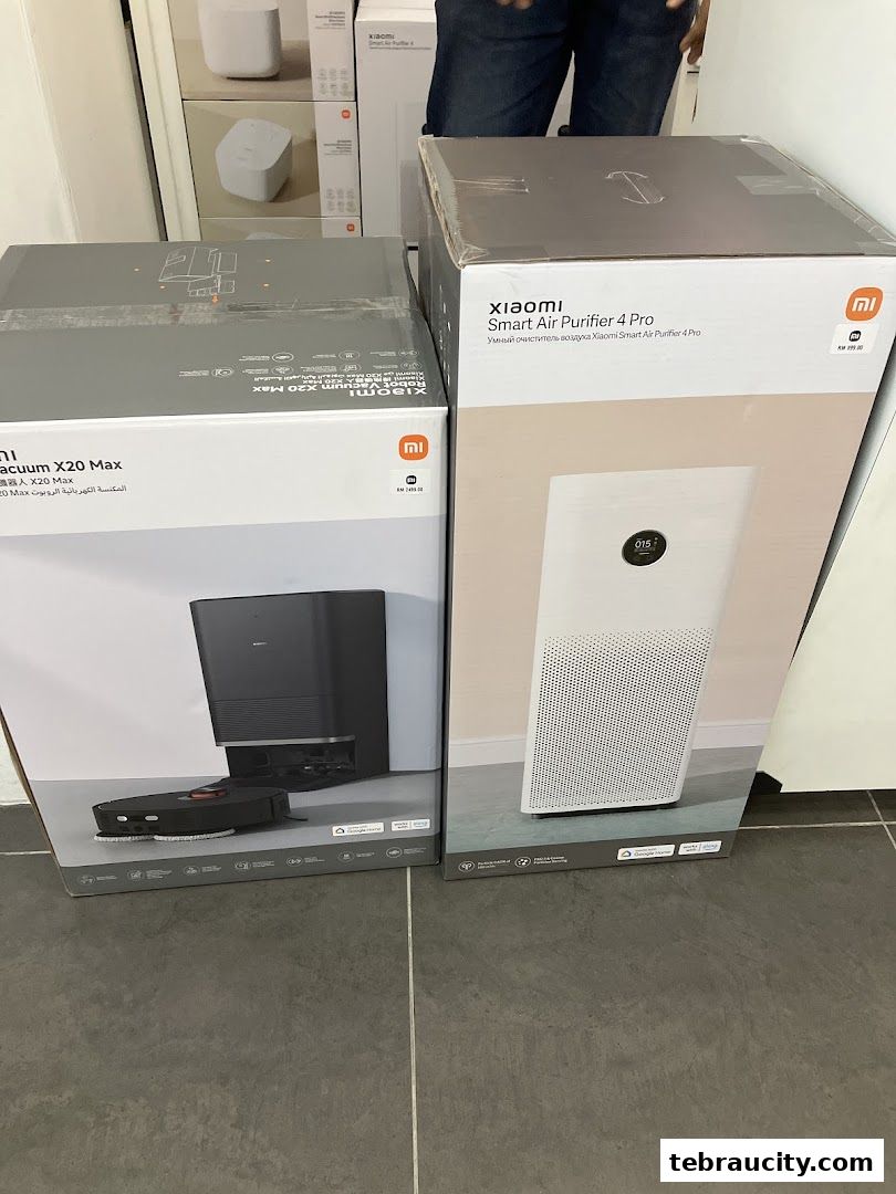 Two Xiaomi product boxes, a robot vacuum and an air purifier, are displayed on the floor.