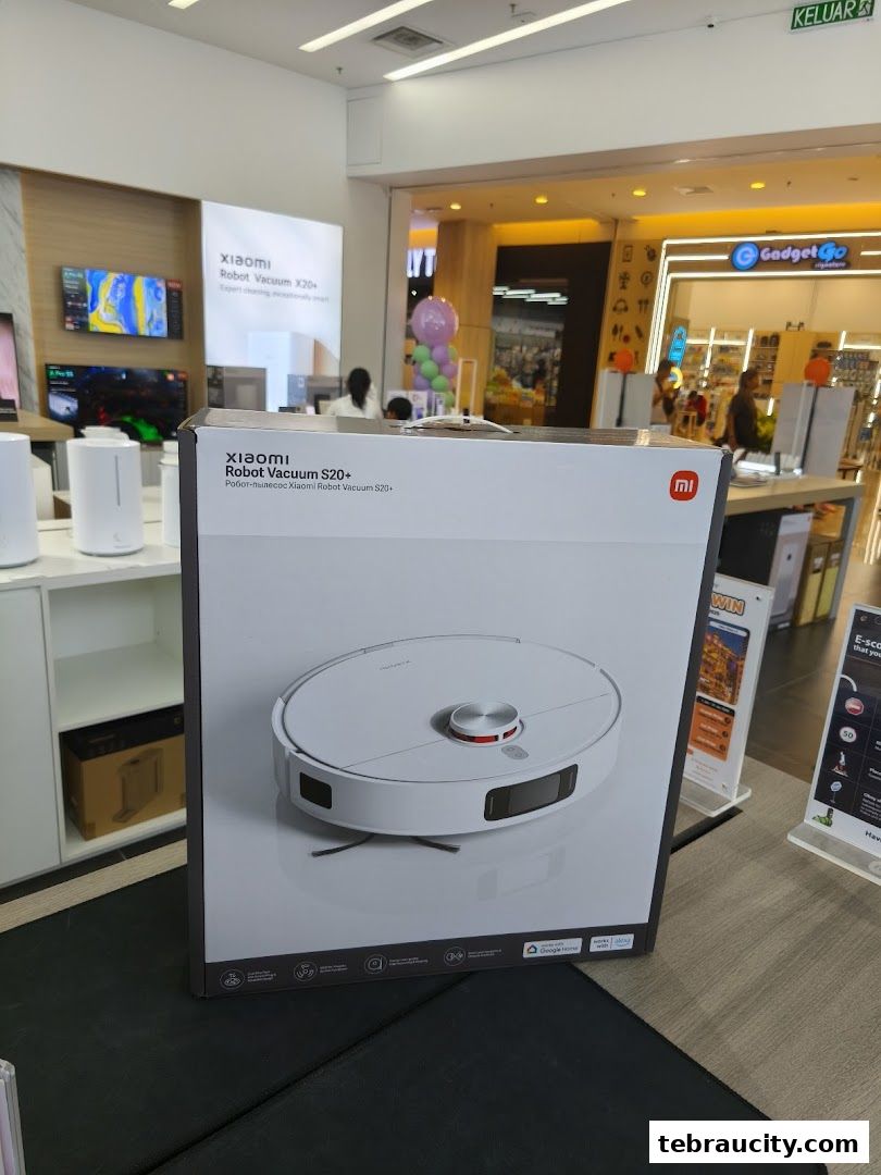 A Xiaomi Robot Vacuum S20+ box is displayed in a store with other products and signage.