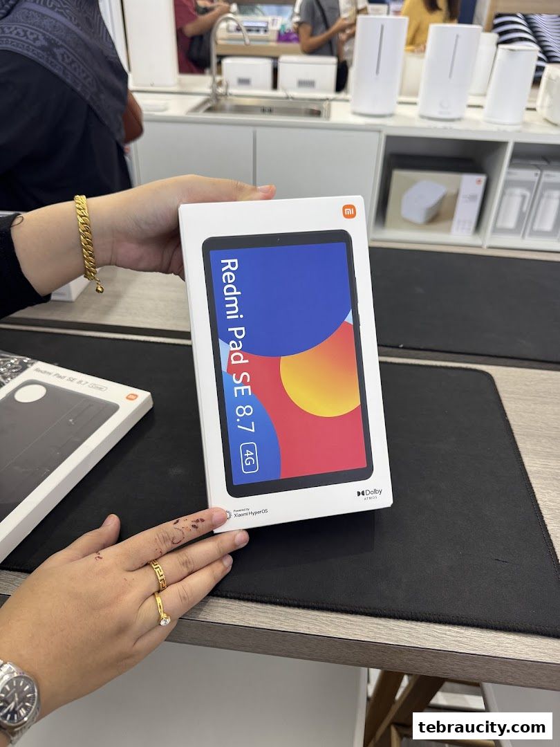 A person holds a box for the Redmi Pad SE 8.7 4G tablet in a Xiaomi store.