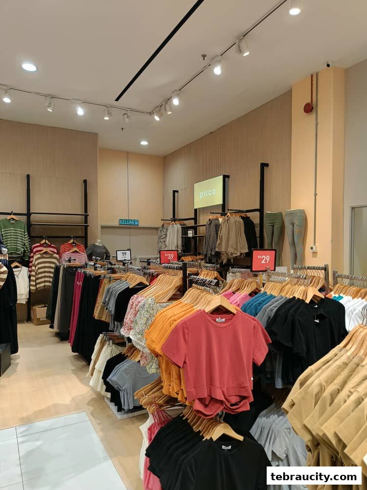 Interior view of a clothing store with racks of colorful tops and apparel.