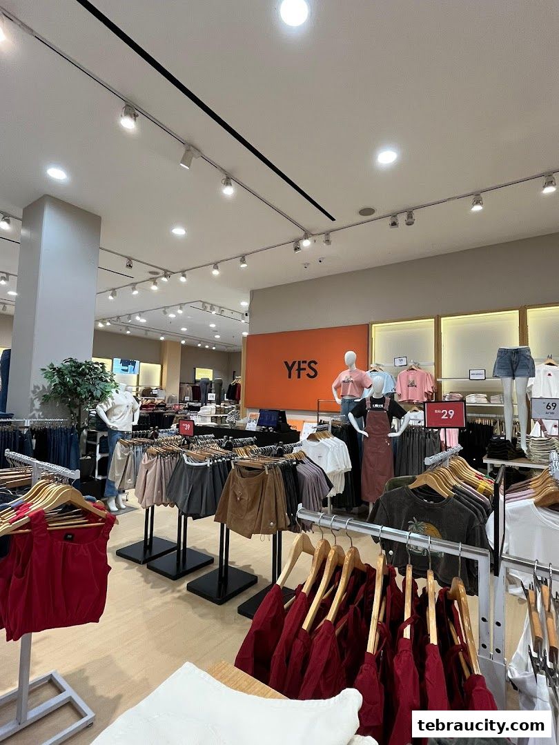 Interior view of a clothing store with racks of apparel and mannequins.